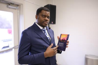 Brother Barel pointing the Anointing Ones brochure